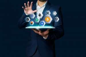 Businessman presenting top cryptocurrency symbols emerging from tablet, blockchain technology concept
