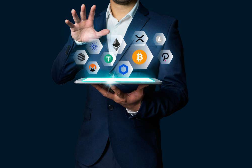 Businessman presenting top cryptocurrency symbols emerging from tablet, blockchain technology concept